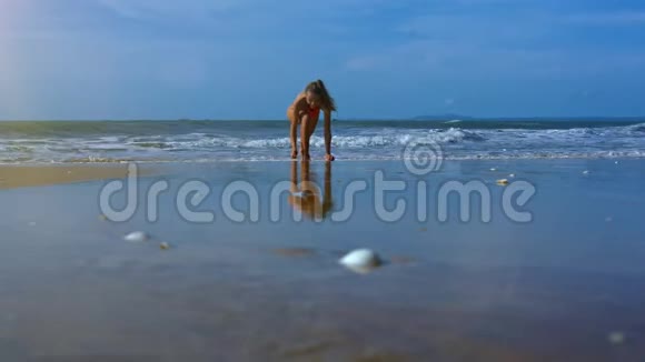 女孩在蓝天下海洋洗沙时手持瑜伽筒视频的预览图