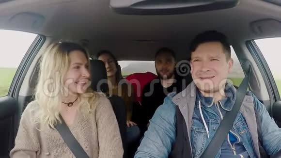 两对年轻的幸福夫妇一起坐车旅行朋友在旅途中听音乐和跳舞视频的预览图