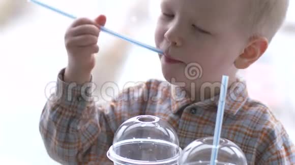 孩子们在快餐店吃午饭男孩喝柠檬水在停车场和城市景观的背景下吃汉堡包视频的预览图