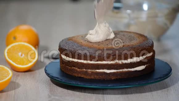 厨师把蛋糕层贴在奶油上烹饪分层蛋糕做分层馅饼巧克力蛋糕层视频的预览图
