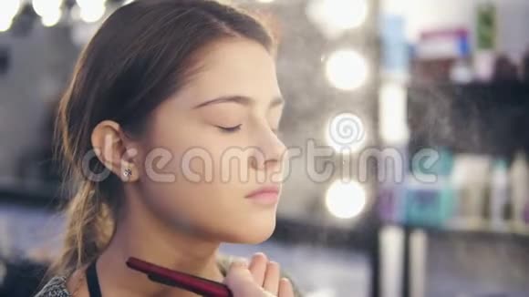 专业化妆师在美容院用喷雾剂年轻女性化妆慢镜头喷雾喷洒视频的预览图