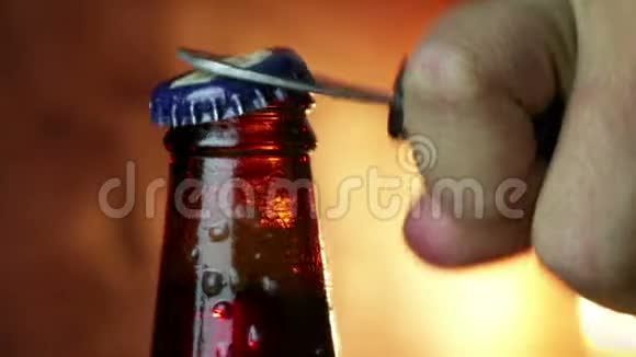 男人打开一瓶啤酒上面放着冰冰冻滴背景是金色的棕色充满乐趣和营养视频的预览图
