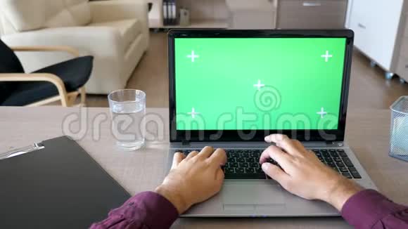 用彩色绿色屏幕模拟的手在笔记本电脑键盘上打字的多利滑块镜头视频的预览图