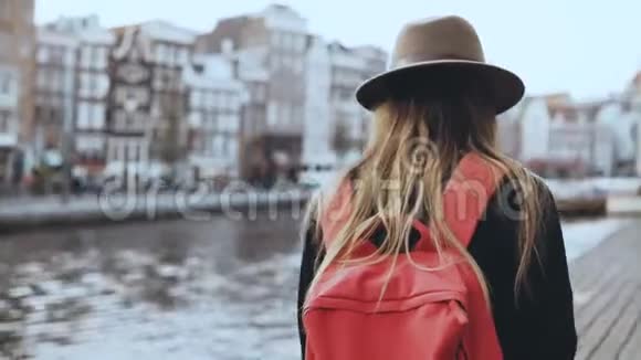 女游客散步在河码头拍照长发女孩红色背包在线发送图片给朋友4K视频的预览图