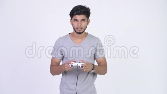 年轻快乐的留胡子的印度男人玩游戏赢球视频的预览图