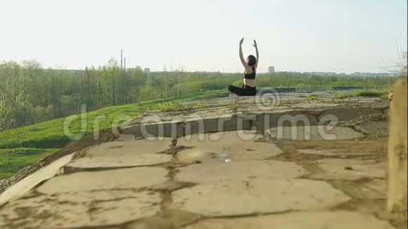 年轻可爱的女孩做体操运动员坐在混凝土板上视频的预览图