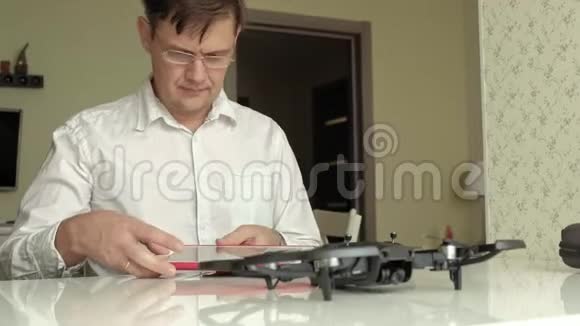 成熟的男人戴着眼镜穿着白色衬衫组装了一架四架直升机连接了控制学习的概念视频的预览图