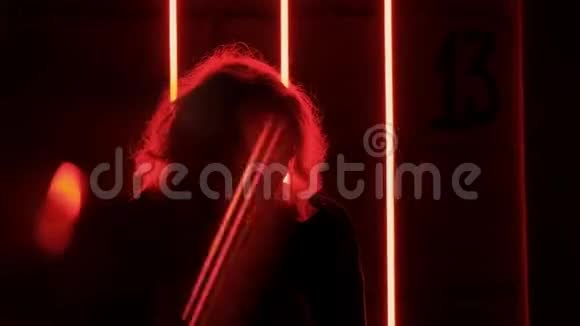 浪漫的白种人金发女人晚上在红色的霓虹灯中跳舞视频的预览图