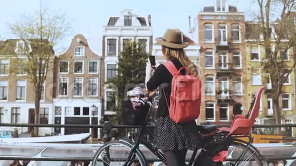 骑自行车的旅游小姐在桥上拍照可爱的高加索女性照片宏伟的古镇建筑4K视频的预览图