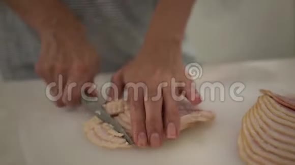 特写一个女孩用刀子在白色的切割板上切割培根动作缓慢视频的预览图