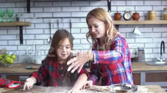无忧无虑美丽的年轻母女在厨房里愚弄妈妈和孩子一起玩得很开心视频的预览图