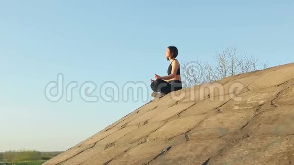 年轻漂亮的女孩坐在水泥板上沉思视频的预览图