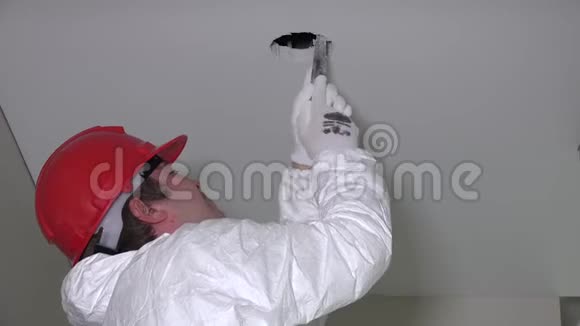 工人为安装照明设备制造干墙天花板孔然后往下爬视频的预览图