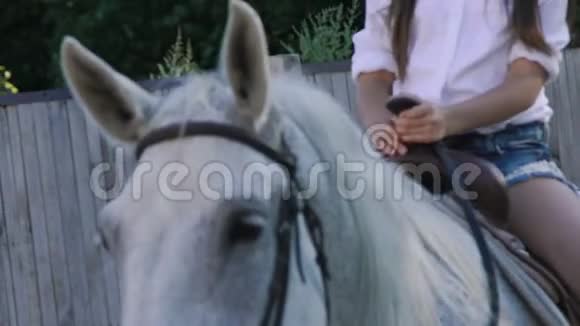 漂亮可爱的年轻女孩骑着一匹友好的马微笑着慢慢地视频的预览图