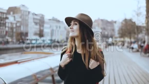 欧洲女游客在河边散步的肖像快乐体贴的旅行者女性在堤岸上环顾四周4K视频的预览图