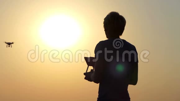 金发摄影师在太阳落山时使用一个飞行的四翼飞行器视频的预览图