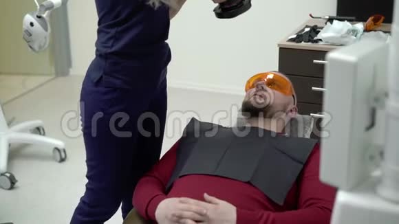 牙科医生在牙科椅上给病人拍照视频的预览图
