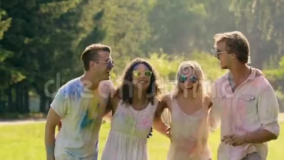 四个快乐的朋友跳着五颜六色的粉末传统的冬青节视频的预览图