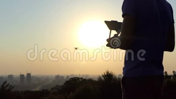聪明的摄影师在太阳落山时使用飞行的四翼飞行器视频的预览图