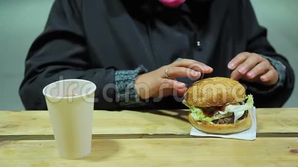 健康问题暴饮暴食在快餐店吃脂肪汉堡的女人视频的预览图