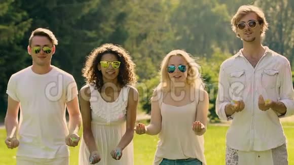 快乐的年轻人在夏季聚会上撒上五颜六色的粉末和拥抱视频的预览图