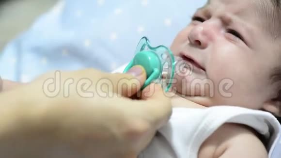 妈妈把奶嘴给宝宝宝宝拿奶嘴安静下来视频的预览图