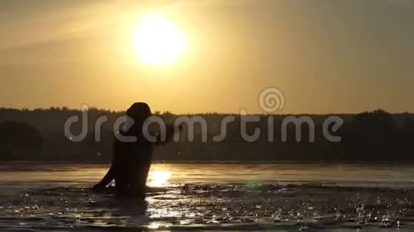 喜气洋洋的人在夕阳西下拍打着湖水尽情娱乐视频的预览图