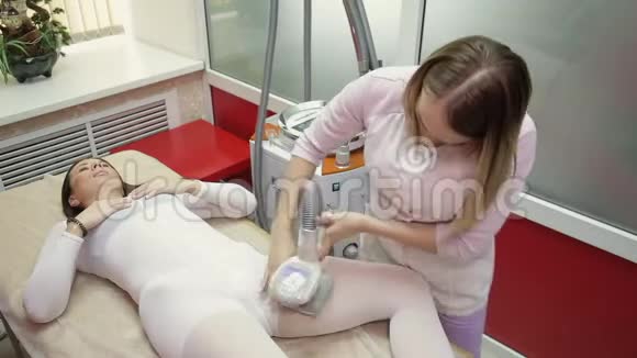 在水疗沙龙里躺在床上按摩液化石油气的女人视频的预览图