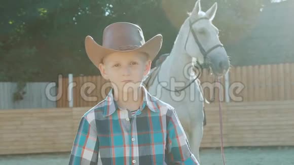 小牛仔的肖像双手交叉在阳光下靠近马慢慢地视频的预览图