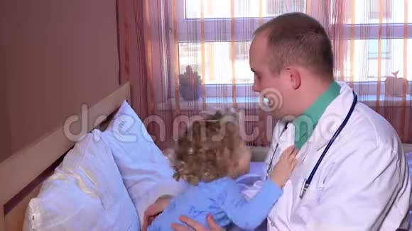 友好的医生在探视期间与三岁的病人玩耍和拥抱视频的预览图
