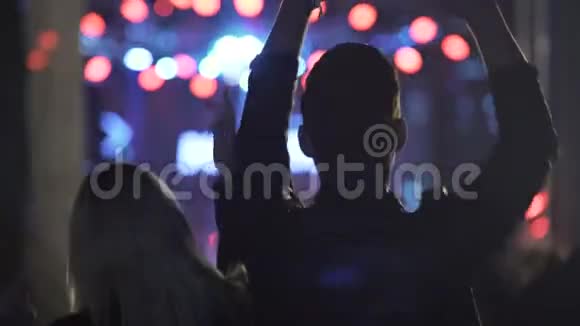 在夜总会的酷乐节上一对精力充沛的情侣在跳舞和挥动双手视频的预览图
