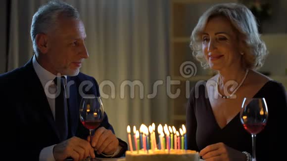 老太太微笑着吹着蛋糕蜡烛庆祝生日庆祝周年纪念日视频的预览图