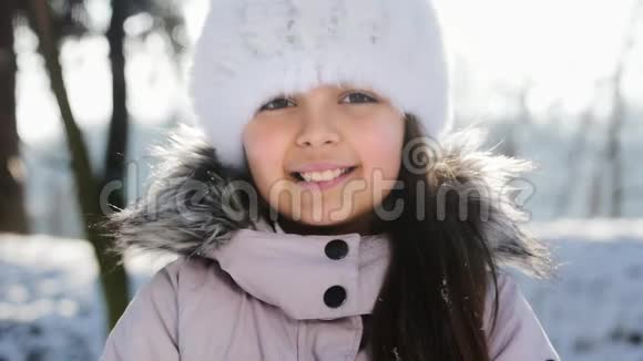 微笑的小女孩吹雪慢动作视频的预览图