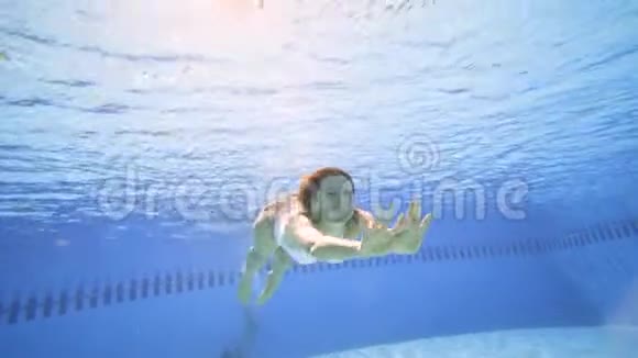 有魅力的女人在游泳池里慢动作游泳视频的预览图