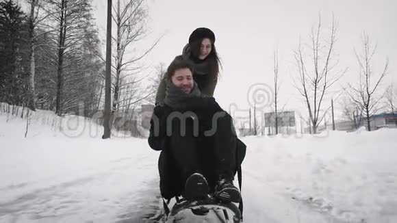 女朋友在雪橇上拉着她的男朋友视频的预览图