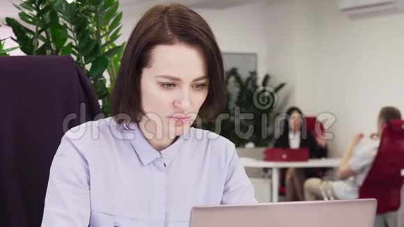 女商人在办公室里用手提电脑和喝咖啡视频的预览图