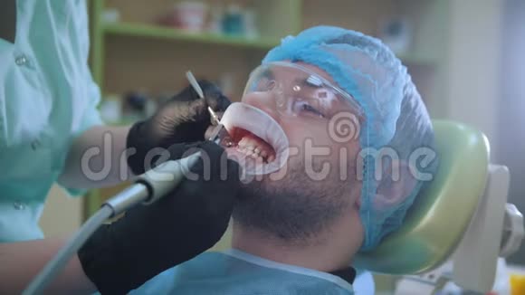 医生和病人在牙科办公室使用唇部扩张器用专用刷子抛光视频的预览图