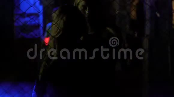 夜店里漂亮的女人在金属铁链栅栏后面诱人地跳舞视频的预览图