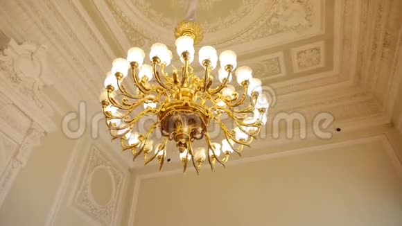 吊在天花板上的大型圆形金色古董吊灯视频的预览图
