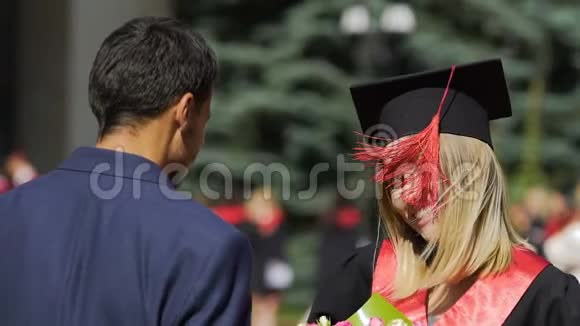 兴奋的年轻女子高兴地拥抱着男亲戚祝贺她毕业视频的预览图