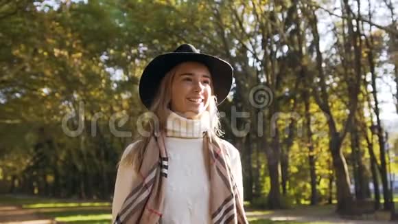 戴着帽子的英俊年轻女人在城市公园散步视频的预览图