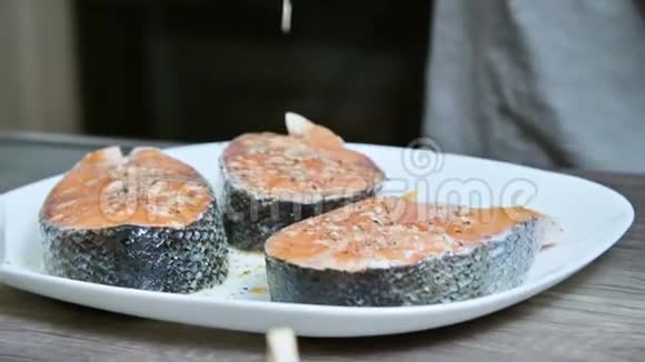 一个烹饪女孩的手的特写她准备新鲜的鱼鲑鱼鳟鱼用柠檬汁浇水挤压柠檬视频的预览图