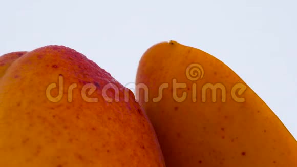 一整半的杏果在转盘上旋转孤立在白色背景上特写镜头宏观视频的预览图