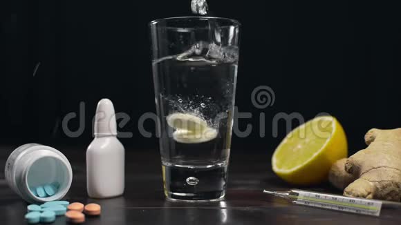 两片阿司匹林和其他药片一起加入到水杯泡腾片维生素和药片中视频的预览图