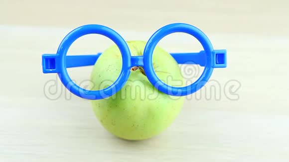 苹果蓝眼镜木桌高清镜头视频的预览图