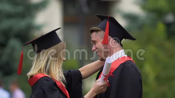 男女朋友拥抱手里拿着高等教育文凭视频的预览图