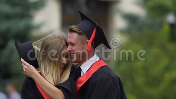 两对即将毕业的学生拥抱在一起梦想着成功的未来视频的预览图