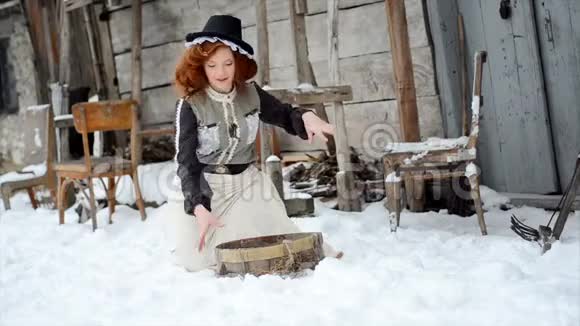 穿着童话裙的女孩站在旧木屋旁撒着雪视频的预览图