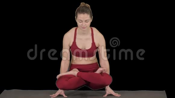 美丽的年轻女性做瑜伽或普拉提锻炼手臂平衡与交叉腿鳞片姿势托拉萨纳Utpluthi视频的预览图