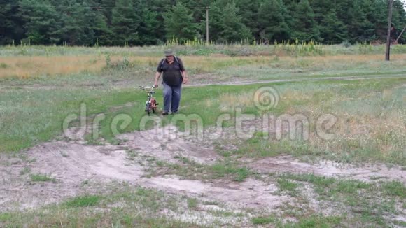 男人走在乡间小路上驾驶着孙子三轮车视频的预览图